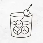 Cocktail mit Eis im Tumbler mit Kirsche garnieren