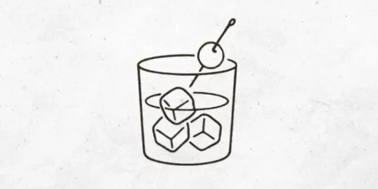 Cocktail mit Eis im Tumbler mit Kirsche garnieren